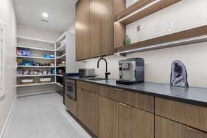 Kitchen featuring open shelves, modern cabinets, wood finish cabinets, and recessed lighting