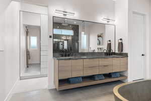 Bathroom with light tile patterned flooring, double vanity, a stall shower, and a freestanding bath