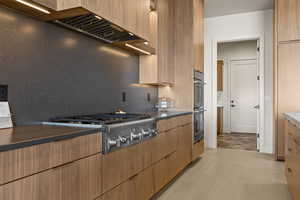 Kitchen with modern cabinets, stainless steel appliances, and dark countertops