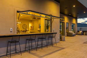 View of patio / terrace with ceiling fan and an outdoor lounge area with bar