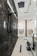 Bathroom with a marble finish shower, recessed lighting, and light tile patterned floors