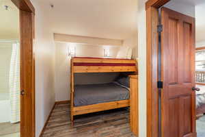 Bedroom featuring wood finished floors and baseboards