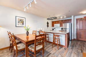 Dining area with track lighting and dark wood finished floors