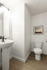 Half bath featuring baseboards and light wood-style floors