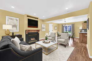 Living area featuring a chandelier, light wood finished floors, a fireplace, and recessed lighting