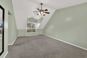 Additional living space featuring carpet flooring, a ceiling fan, and vaulted ceiling
