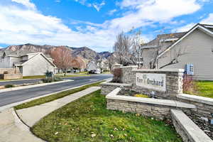 Community sign with a residential view, a yard, and a mountain view