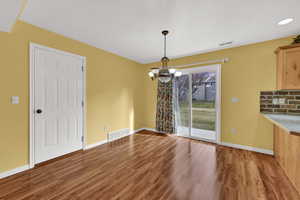 Unfurnished dining area featuring a chandelier and light wood-type flooring