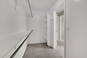 Walk in closet featuring light carpet