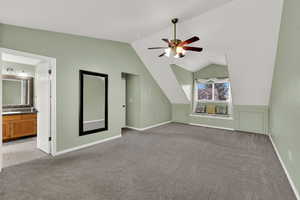 Additional living space with light colored carpet, vaulted ceiling, and a ceiling fan