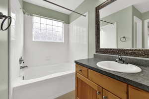 Full bathroom featuring tub / shower combination, vanity, and light tile patterned floors