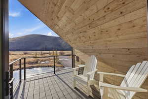 Private balcony featuring wood-finish decking and natural wood paneling