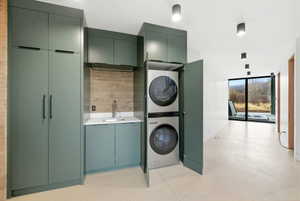Integrated laundry area featuring stacked appliances within custom cabinetry