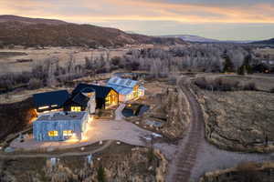 Aerial view of property and surrounding area featuring a mountain backdrop
