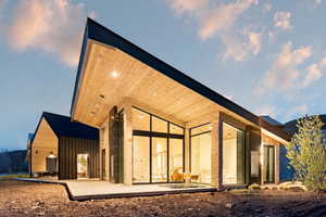 Modern architectural design featuring a prominent angular roofline with wood-finish soffit