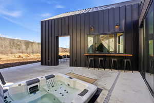 View of patio with an outdoor hot tub