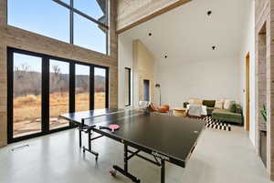 Recreation room with lofted ceiling and concrete floors