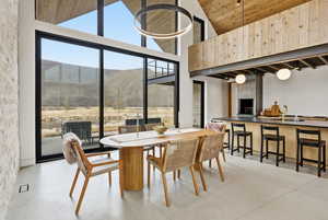 Dining area featuring finished concrete floors, a mountain view, and a vaulted wood ceiling