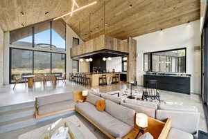 Vaulted wood-finish ceilings throughout a spacious living area featuring polished concrete flooring