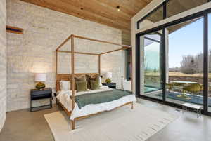 Stone accent wall with a vaulted wood-plank ceiling