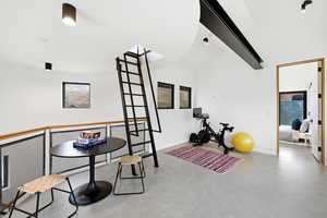 Exercise room with finished concrete floors and vaulted ceiling