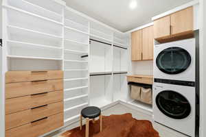 Laundry room with stacked washer / dryer and cabinet space