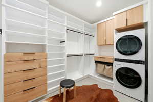 Custom closet system featuring white shelving and natural wood-tone drawer fronts