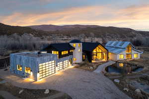 View of front facade featuring gravel driveway, a garage, a mountain view, and a standing seam roof
