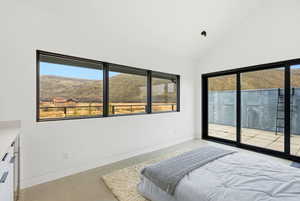 Spacious room featuring a vaulted ceiling and concrete flooring