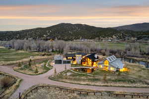 Modern architectural property with multiple structures, natural surroundings, and a prominent water feature