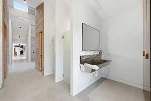 Contemporary hallway featuring high ceilings and light wood-paneled walls