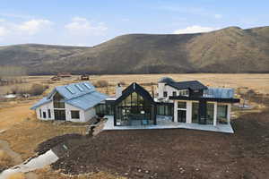 Back of property featuring a chimney, a patio, a mountain view, and a rural view