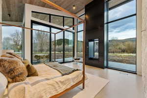 Spacious room featuring floor-to-ceiling windows, a wood-paneled ceiling, and light-toned flooring
