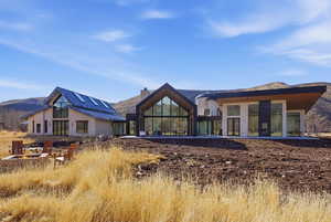 Rear view of house featuring a chimney, a patio, a mountain view, and an outdoor fire pit