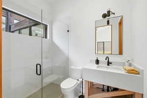 Modern bathroom featuring a frameless glass shower enclosure, a white vanity with an integrated sink, and a black framed mirror