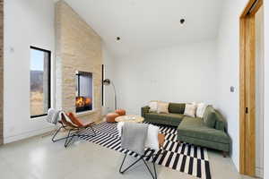 Living room with vaulted ceiling and a stone fireplace