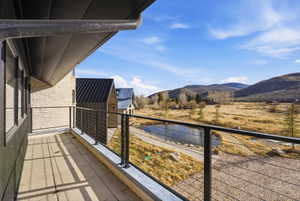 Spacious balcony featuring stone tile flooring and a modern cable railing system
