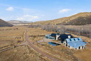 Expansive property featuring two distinct structures, a gravel driveway, and natural landscaping
