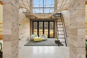 Interior space featuring a rope net suspended from the ceiling, a black metal ladder, and wood-paneled walls