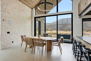 Dining space featuring a mountain view, concrete flooring, and lofted ceiling