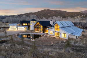 Modern architectural design featuring multiple structures, a silo-inspired element, and a contemporary garage with glass panel doors