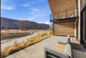 Patio / terrace featuring a water and mountain view and a patio area