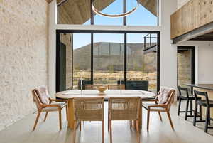Dining area featuring a vaulted ceiling with exposed wood-finish beams and a contemporary circular light fixture