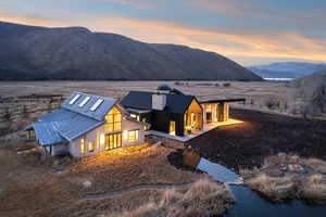 View of front of house with a standing seam roof, a mountain view, and a chimney