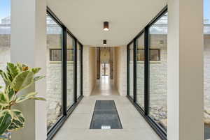 Hallway featuring floor to ceiling windows and healthy amount of natural light