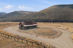 Stone-clad barn structure featuring a brown metal roof and cupola