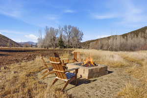 View of yard featuring a mountain view, an outdoor fire pit, and a patio