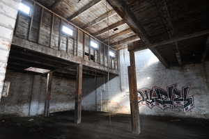 Misc room featuring brick wall and a high wooden ceiling