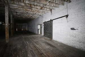 Miscellaneous room with brick wall and a barn door