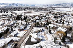 Snowy aerial view with a mountain view and a residential view